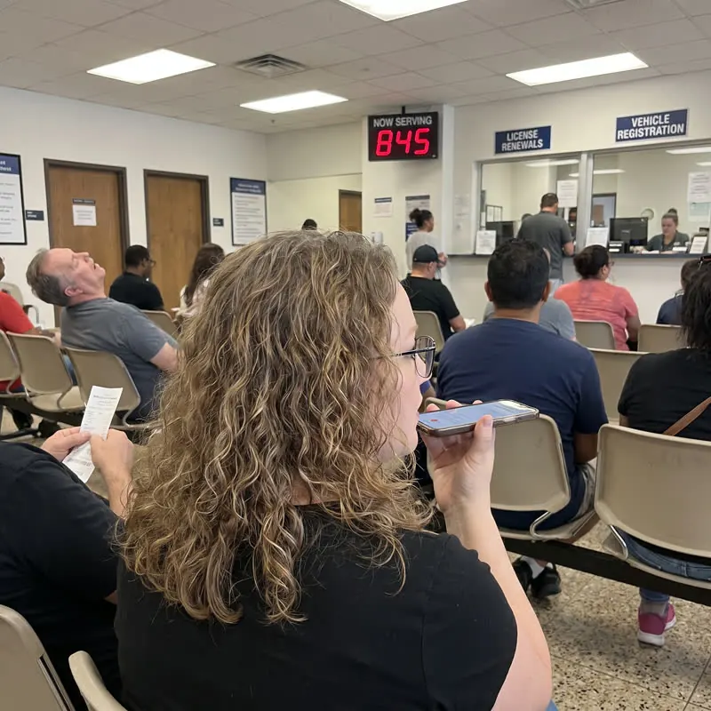 Bridget talking into her phone in a waiting room