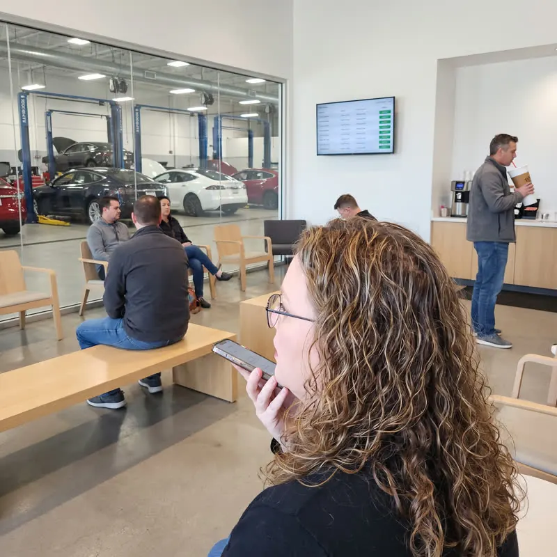 Bridget talking into her phone in a service lounge